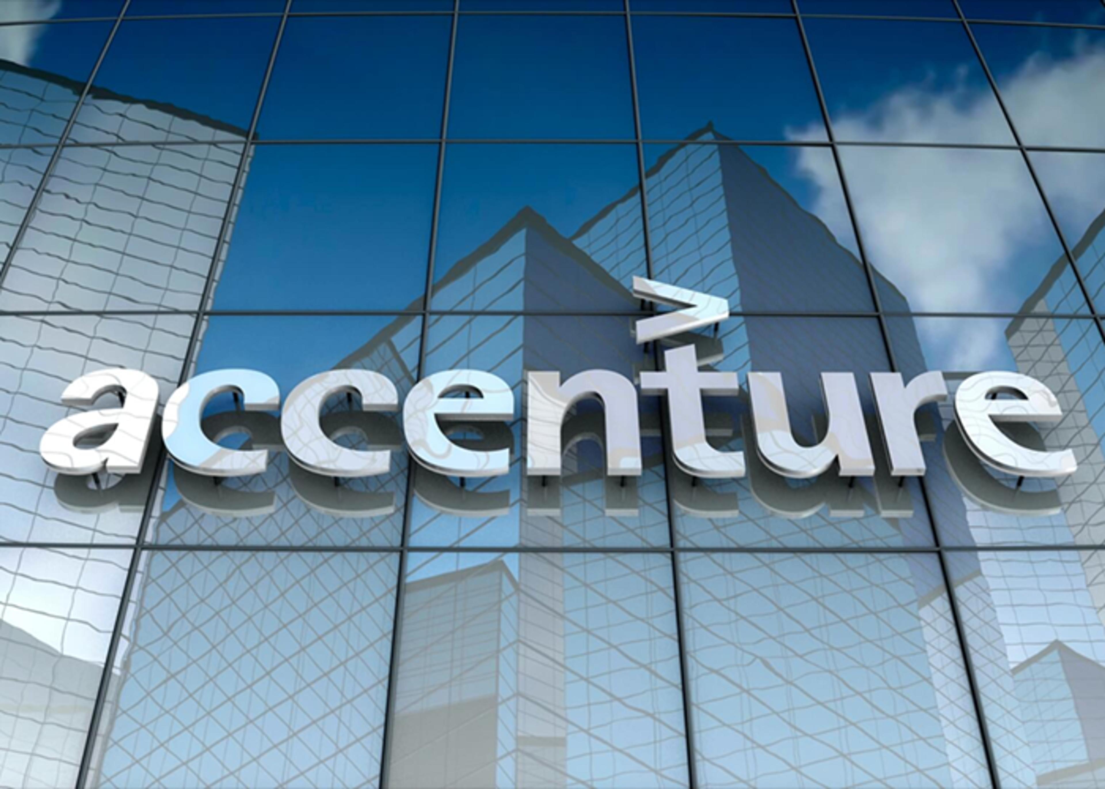 The Accenture logo is displayed on the glass exterior of a modern office building, reflecting the surrounding cityscape.