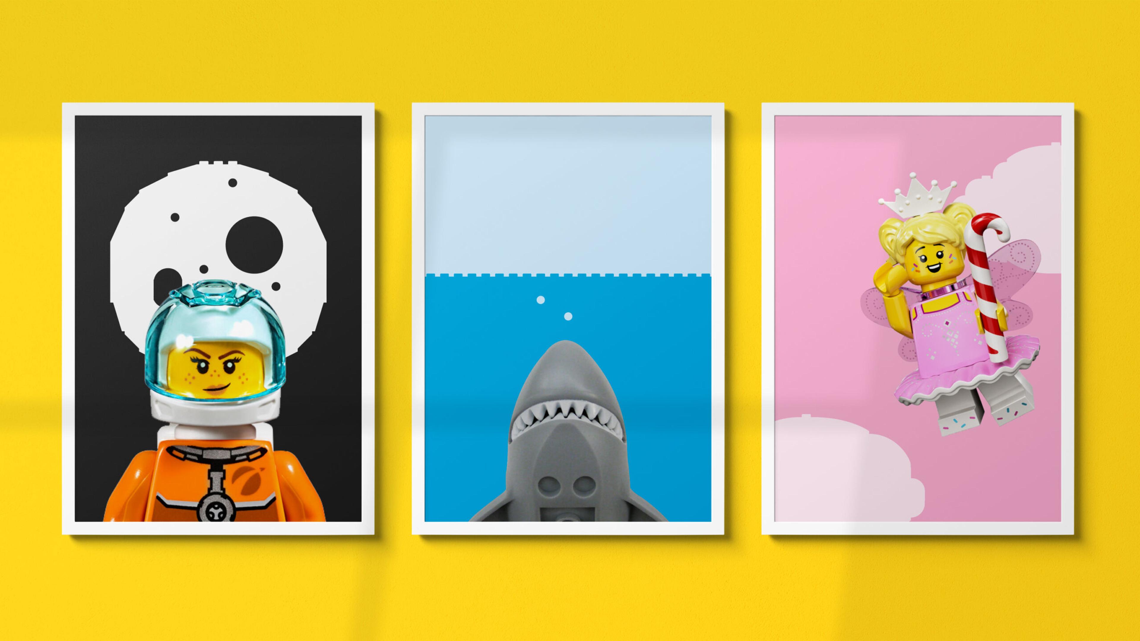 Three framed prints on a bright yellow wall showcase whimsical LEGO-themed art. The first depicts a LEGO astronaut against a lunar backdrop. The second shows a LEGO shark in blue water. The third presents a LEGO fairy princess against a pink background.