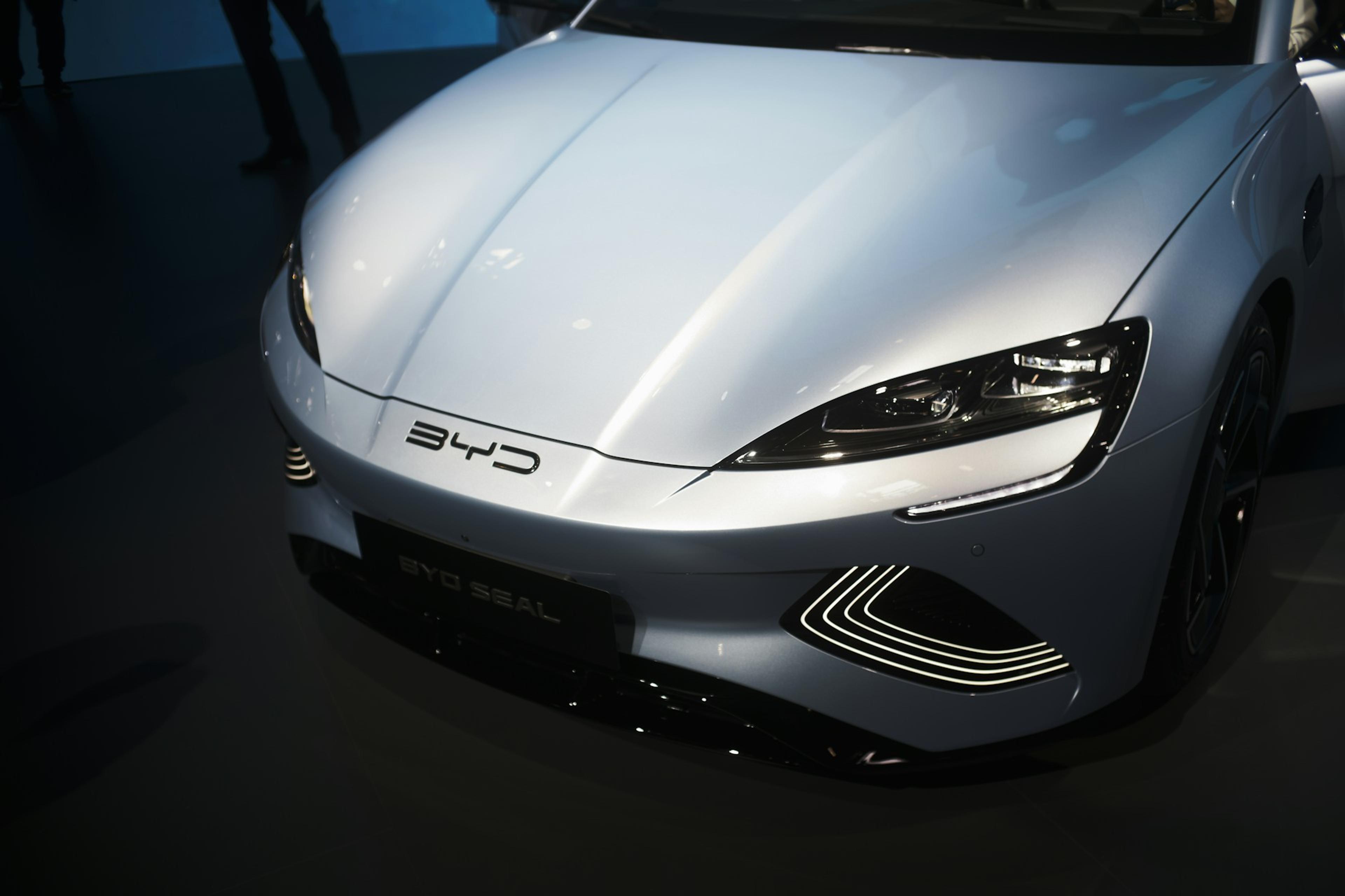 Close-up of the front driver's side of a silver BYD Seal electric vehicle, highlighting the headlights and bumper design.