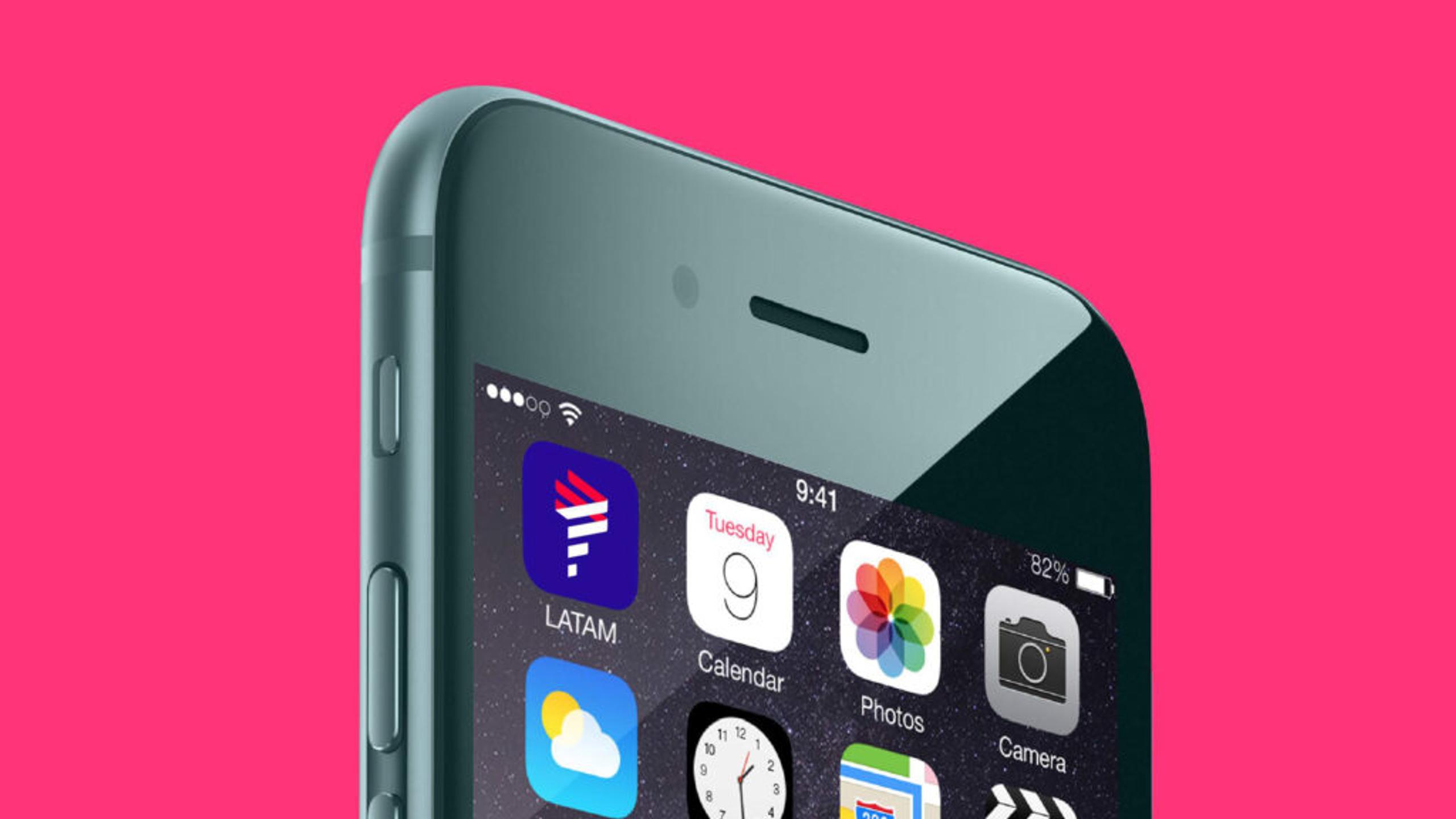 Close-up of a gray cellphone against a pink background showing the home screen with icons for LATAM, Calendar, Photos, and Camera. The time displayed is 9:41 and the battery is at 82%.